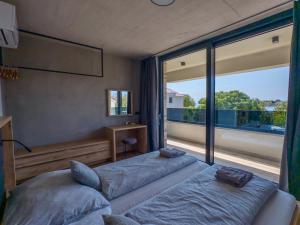 a bedroom with two beds and a large window at Villa Privlaka Travertino in Privlaka