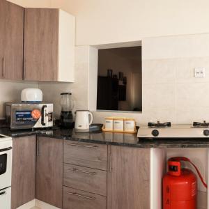 a kitchen with a counter top with a red appliance at EAGLE WEAVERS NEST in Livingstone