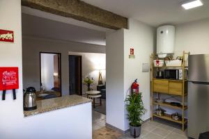a kitchen and a living room with a refrigerator at Casa Da Eira Caramulo in Varzielas