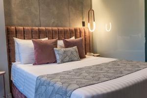 a bedroom with a large bed with pillows at The O by Seekers Medellín in Medellín