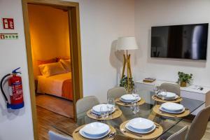 a dining room with a table and chairs and a bed at Casa Da Eira Caramulo in Varzielas