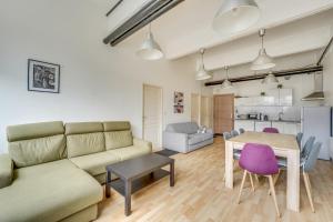 a living room with a couch and a table at Les LILAS in Les Lilas