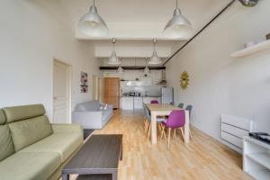 a living room with a couch and a table at Les LILAS in Les Lilas