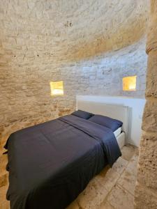 a bedroom with a bed in a stone wall at Masseria Camerlengo in Castellana Grotte