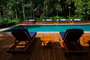 two chairs and a table next to a swimming pool at Fazenda Shanti in Alto Paraíso de Goiás