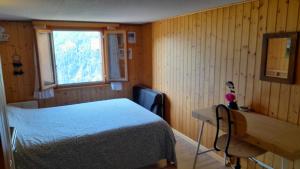 a bedroom with a bed and a desk and a window at Chalet del Sole in Quinto