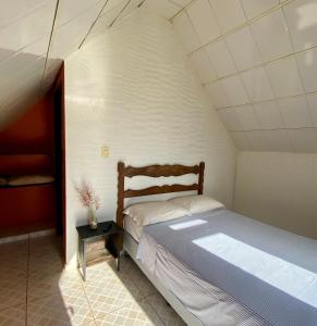 a small bedroom with a bed and a table at Chalés Vale Encantado - Serra do Cipó in Jaboticatubas