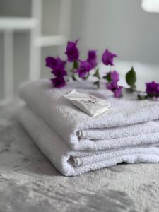 a pile of towels with purple flowers on top at Hotel Tropical in Torres +26 photos