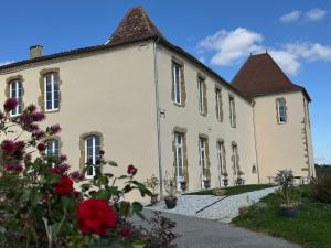 a large white building with flowers in front of it at Château de Mauhic - 15th century in Loubédat