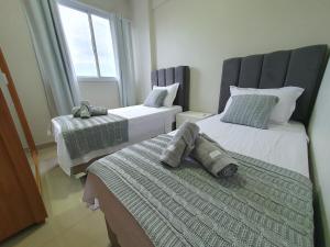 a bedroom with two beds and a window at Praia da Graciosa Apartamento 2 quartos in Palmas