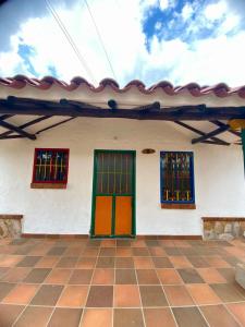 a white building with colorful doors and windows at Hotel Arcoiris Mesa de los Santos in Los Santos