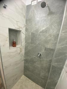 a shower with a glass door in a bathroom at Hotel Arcoiris Mesa de los Santos in Los Santos +23 photos
