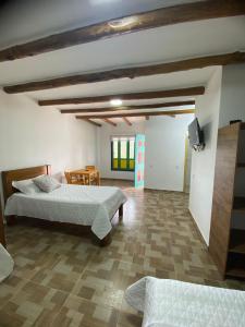 a large room with two beds and a table at Hotel Arcoiris Mesa de los Santos in Los Santos