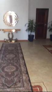 a living room with a rug and a mirror at ESSERa1 in Nouakchott