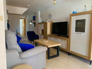 a living room with a couch and a television at Casa Pera Ático duplex 1ª in Chilches