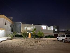 a white car parked in front of a house at night at ESSERa1 in Nouakchott