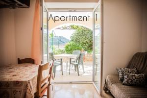 an open door to a patio with a table and chairs at Apartments Skapul in Lopar