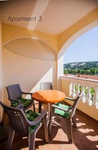 a table and chairs in a room with a balcony at Apartments Skapul in Lopar