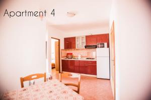 a kitchen with a table and a white refrigerator at Apartments Skapul in Lopar +67 photos