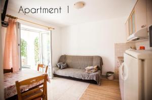 a living room with a couch and a table at Apartments Skapul in Lopar