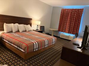 a hotel room with a bed and a flat screen tv at Regency Inn & Suites in Milton +49 photos