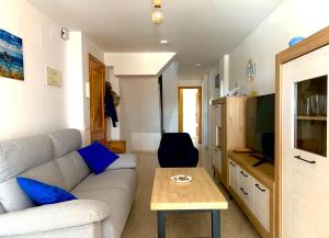 a living room with a couch and a tv at Casa Pera Ático duplex 1ª in Chilches