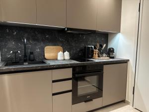 a kitchen with white cabinets and a counter top at AuRa The Golden Suite in Alexandroupoli +16 photos