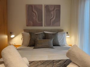 a bedroom with a large bed with pillows at AuRa The Golden Suite in Alexandroupoli