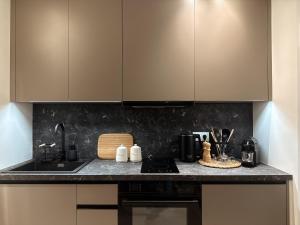 a kitchen with brown cabinets and a counter top at AuRa The Golden Suite in Alexandroupoli