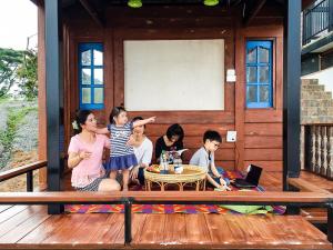 a group of children sitting on a porch at Mekong Tarawadee Villa in Tha Bo