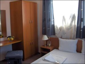 a bedroom with a bed and a cabinet and a window at Sargas Sozopol in Sozopol