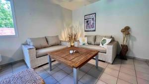 a living room with a couch and a table at MOOREA - Waterfall Pool Coconut House 1 in Pihaena