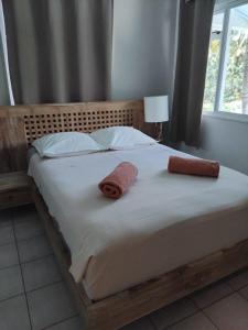 a bed with two towels on top of it at MOOREA - Waterfall Pool Coconut House 1 in Pihaena +8 photos