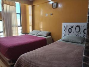 a bedroom with two beds and a window at Hostal Sin fronteras in Uyuni
