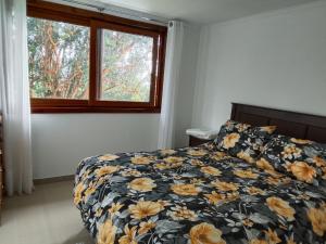 a bedroom with a bed and a window at Regreso al Encanto in Puyehue