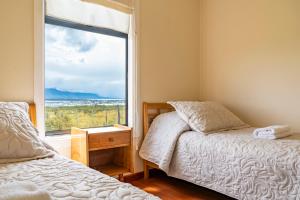 a bedroom with a bed and a window at Kayenwuouk, Puerto Natales in Puerto Natales