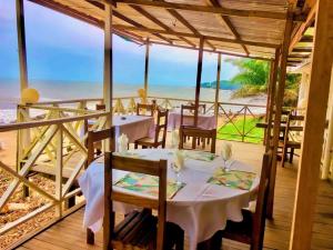 a dining room with a table and chairs and the ocean at appartment émeraude in Kribi