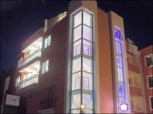a tall building with lit up windows at night at Sargas Sozopol in Sozopol