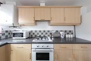 a kitchen with wooden cabinets and a white stove top oven at Valley View in Shield Row