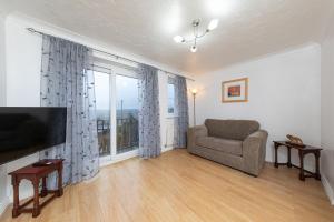 a living room with a couch and a large window at Valley View in Shield Row