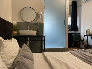 a bathroom with a sink and a bed and a mirror at E - Central Room Five in Skopje