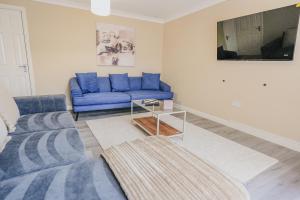 a living room with a blue couch and a table at Dunward House in Livingston