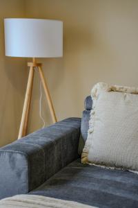 a lamp sitting next to a blue couch with a pillow at Dunward House in Livingston +31 photos