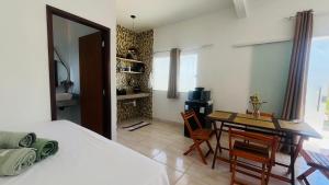 a bedroom with a bed and a table and a dining room at Quitinetes espaçosos com ar para um casal na Ilha de Boipeba in Ilha de Boipeba