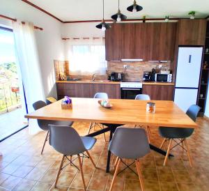 a kitchen with a large wooden table and chairs at Sea view house II in Dhílesi