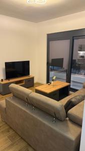 a living room with a couch and a flat screen tv at Morea Apartments in Ulcinj