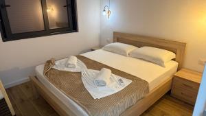 a bedroom with a bed with two towels on it at Morea Apartments in Ulcinj