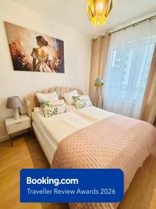 a bedroom with a bed and a painting on the wall at Lotus Apartments Impero separate kitchen two rooms parking balcony in Ostrołęka