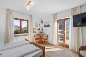 a bedroom with a bed and a table and chairs at Gästehaus Florian in Grainau