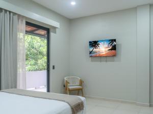a white bedroom with a bed and a window at Miradora House in El Sunzal
